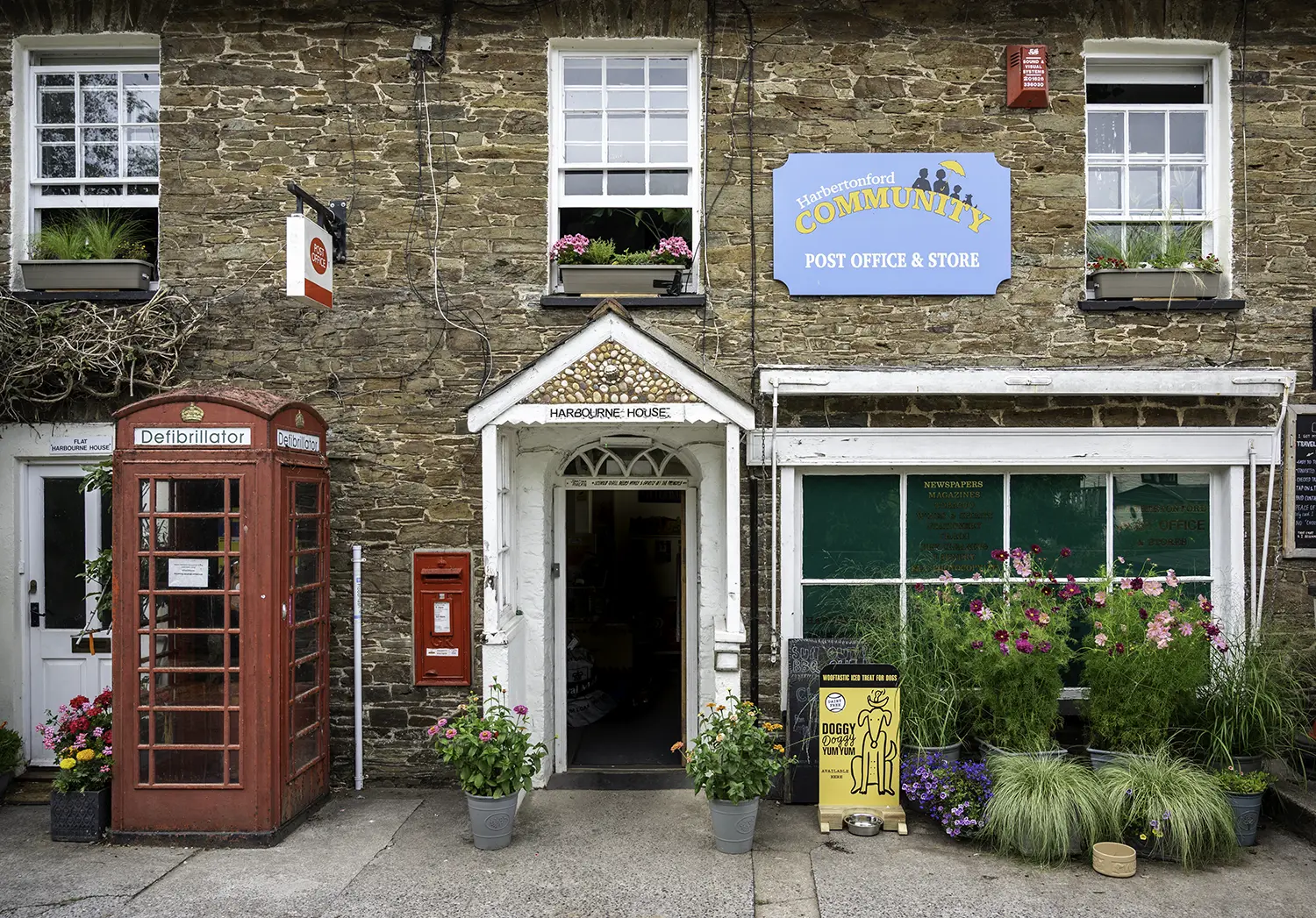 Harbertonford Community Shop and Post Office with traditional stone building, village post office entrance and community store.